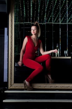 Full length portrait of young woman sitting on sofa in nightclub