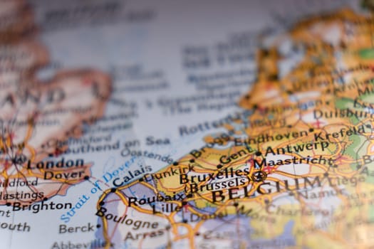 Close up detail of a colorful map focusing on Brussels, Belgium through selective focus, background blur.