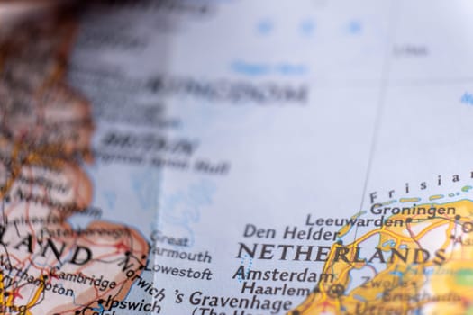 Close up of a colorful map focusing on Amsterdam, Netherlands through selective focus, background blur.