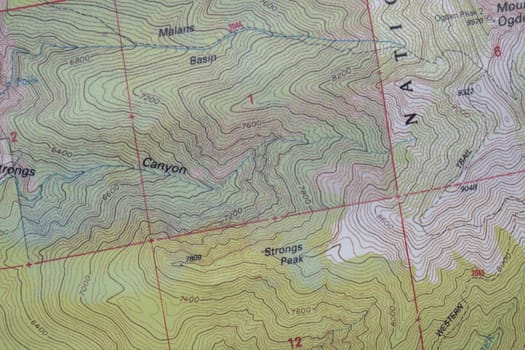 Close-up detail of topographical contour map with elevation lines, mountain peaks