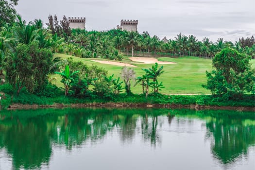 Scenic view beautiful golf course pond castle background view green lawn forest Reflection trees bush lush in water scenery valley lake country park.