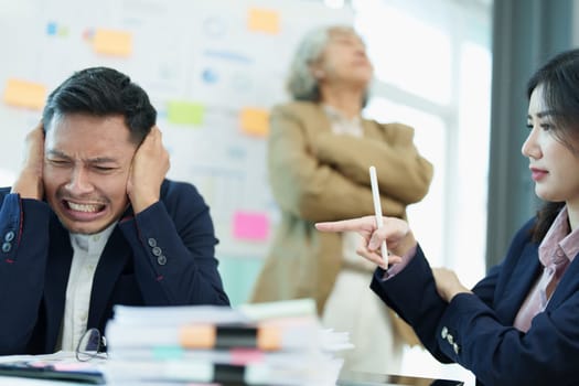 An image of an Asian male employee looking worried and sad about being scolded by his boss for failing to meet sales targets, concept of disappointment and failure in his career.