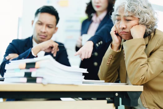 An image of an Asian male employee looking worried and sad about being scolded by his boss for failing to meet sales targets, concept of disappointment and failure in his career.