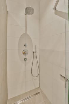 a shower with green trim on the wall and white tile in the shower stall door is open to show how it's done