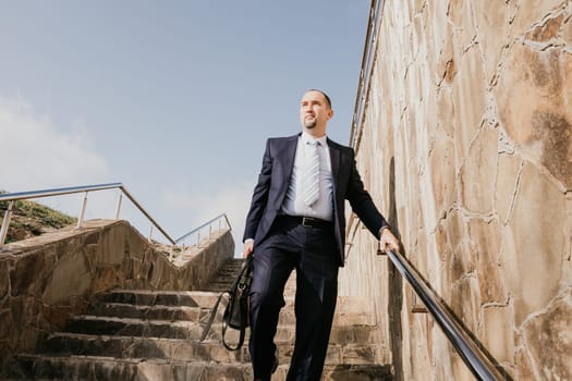 Business executive with briefcase going down the stairs.