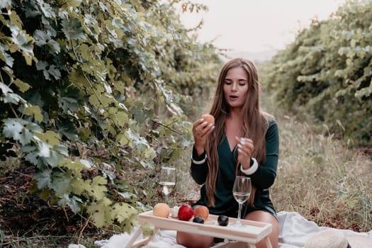 Picnic and wine tasting at sunset in the hills of Italy, Tuscany. Vineyards and open nature in the summer. Romantic dinner, fruit and wine.