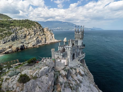 Aerial view of Swallow's Nest castle on the rock in Black Sea. It is a symbol and landmark of Crimea. Beautiful scenic panorama of the Crimea coast. Amazing Swallow's Nest at the precipice.