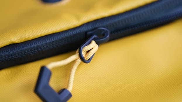 Black lock on yellow fabric backpack closeup. Reliable protection when storing things concept