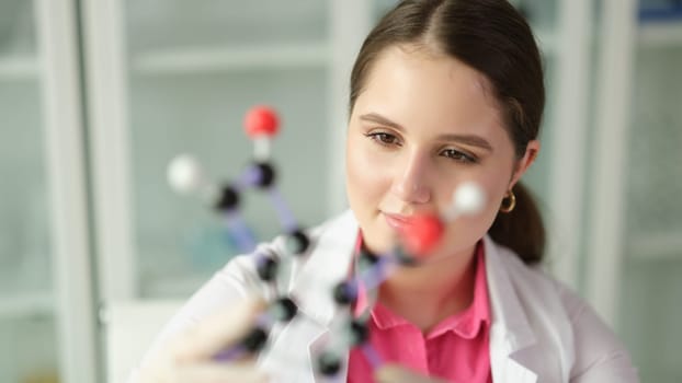 Woman scientist chemist in front of molecule in chemical laboratory. Genetic engineering concept