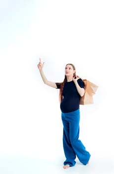 Shopping concept: Young pregnant woman with shopping bags full length portrait on white background.
