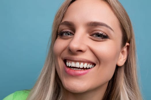close-up of a healthy young blond woman with a Hollywood smile on a blue background.