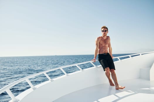 Young male tourist is on the yacht on the sea. Conception of vacation.