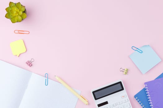 Open notebook with a yellow pencil on a pink background with copy space. Back to school concept. Top view. Spiral notepad with stickers. Flat lay.