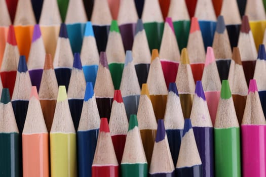 Macro photography of colored pencils. Background of colorful sharpened colored pencils. Stationery set for drawing and coloring