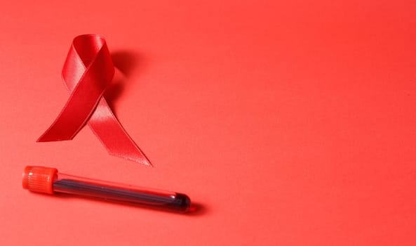 Cancer ribbon on red grunge background. Health care. AIDS prevention concept. Flask and syringe with blood. Hiv and cancer awareness.