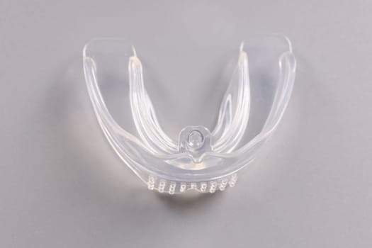 Silicone plastic tooth cap orthodontic trainer for bite correction. Advantages and disadvantages of mouthguards for teeth alignment concept