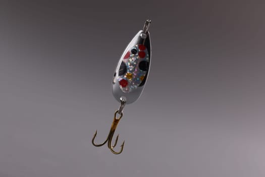 Fishing tackle with bait and hook on gray background. Fishing accessories concept