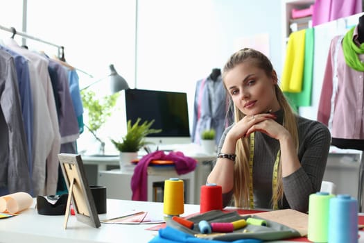 Beautiful woman designer stylist at workplace in creative studio. Seamstress and training in tailoring concept