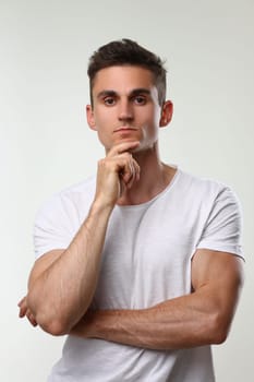 Portrait of young handsome athletic man in white t-shirt. Male brutality and masculinity concept