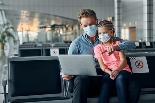 With little girl. Young man in formal wear is in modern airport.