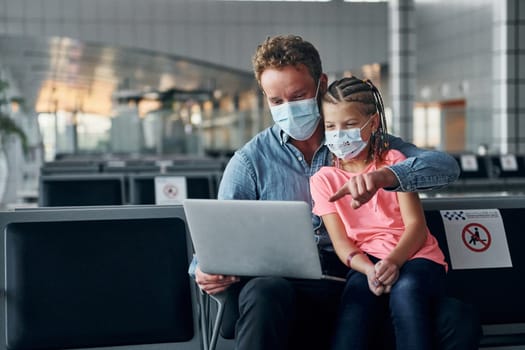 With little girl. Young man in formal wear is in modern airport.