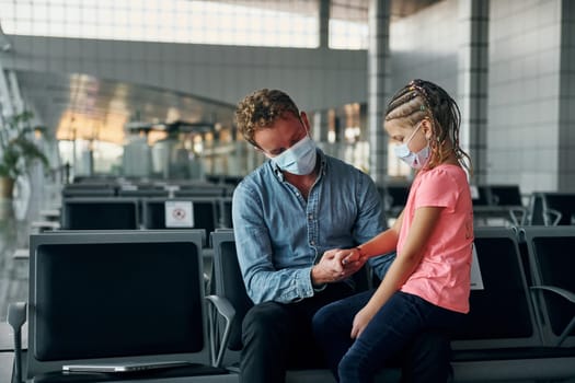 With little girl. Young man in formal wear is in modern airport.