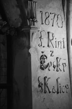 Grayscale shot of lettering made of human bones in the Sedlec Ossuary in Kutna Hora, Czech Republic