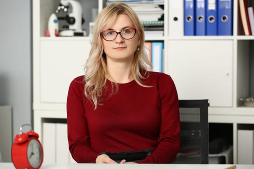 Portrait of businesswoman in glasses at workplace in office. Secretary manager and business assistant concept