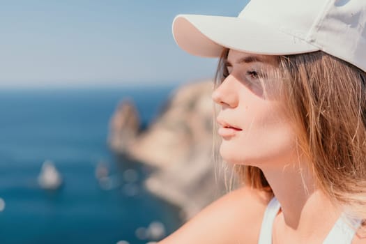 Woman travel sea. Young Happy woman in a long red dress posing on a beach near the sea on background of volcanic rocks, like in Iceland, sharing travel adventure journey