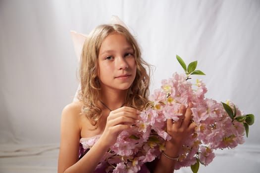 Portrait of cute kid girl posing in pink beautiful dress on white background. Model in studio looking as gentle magic princess from fairy taly having photo shoot on white background