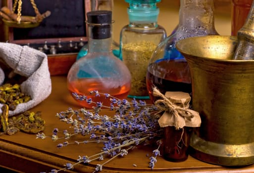 Close up of healing herbs alchemist stuff. Old pharmacy, alternative medicine concept. Dried healing herbs, flowers and candles, ritual purification , copyspace mortar and pestle near potions on wooden table.