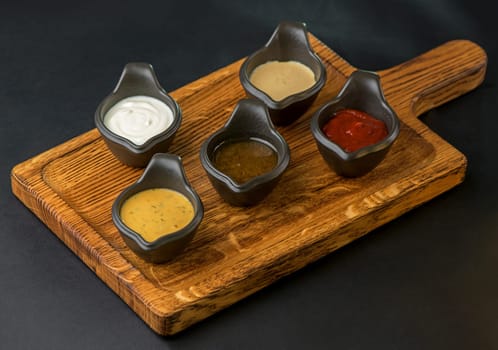 different sauces on black background
