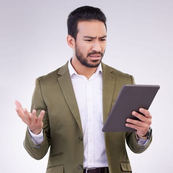 Problem, confused and Asian man with a tablet for communication isolated on a white background in a studio. Unhappy, frustrated and a Japanese businessman reading bad news on technology on backdrop.
