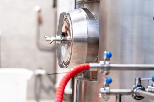 stainless steel boilers and vessels with pipes for brewing beer in a brewery.