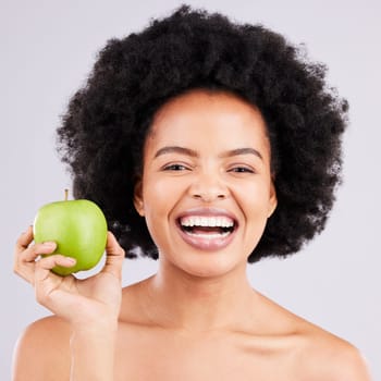 Portrait, health and black woman with apple, diet and happiness against a grey studio background. Face, African American female and lady with fruit, wellness and healthy lifestyle with smile and joy.