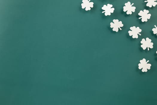 Happy St Patricks Day decoration background. above top view of paper clover leaves festive decor, shamrocks leaves holiday symbol with copy space on colour background, Banner greeting card concept