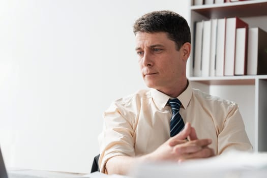 Handsome businessman working with laptop in office.