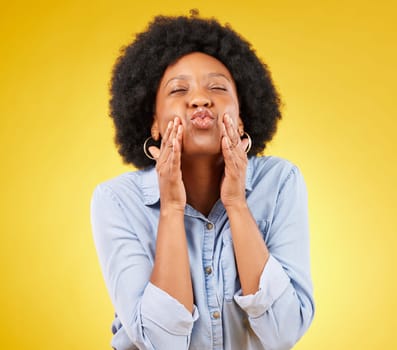 Happy, blow kiss and black woman in a studio for love, romance or flirting face gesture. Happiness, sensual and African female model with a romantic kissing facial expression by a yellow background