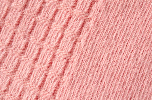 Texture of a knitted woolen pink color cloth. Background.