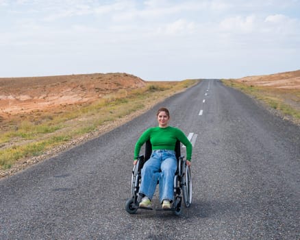 Woman in a wheelchair on a highway in the steppes