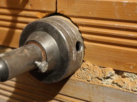 drilling a hole for an outlet in a brick wall with a puncher close-up