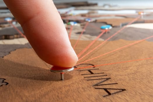 Close up man pushes pin with China flag into wooden map. Visited the country on the vacation concept