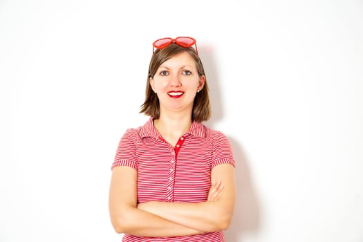 Portrait of the young smiling attractive woman with red heart sunglasses on the white background. High quality photo.