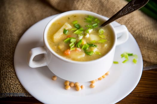 dried pea soup in a plate with herbs, on a wooden table.