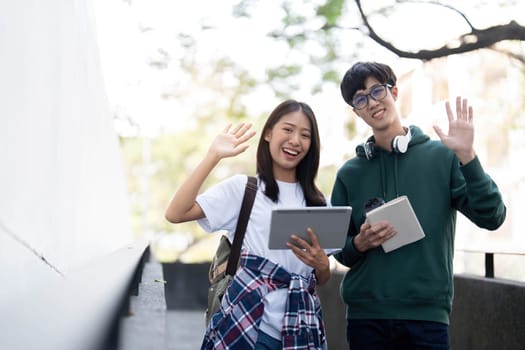 Group of Asian college student reading books and tutoring special class for exam on grass field at outdoors. Happiness and Education learning concept. Back to school concept. Teen and people theme...