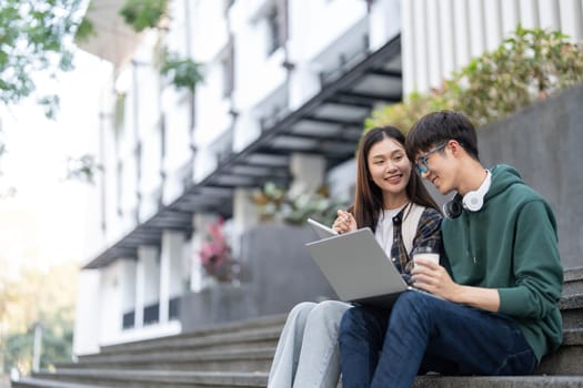 Group of Asian college student reading books and tutoring special class for exam on grass field at outdoors. Happiness and Education learning concept. Back to school concept. Teen and people theme...