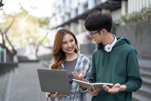 Group of Asian college student reading books and tutoring special class for exam on grass field at outdoors. Happiness and Education learning concept. Back to school concept. Teen and people theme...