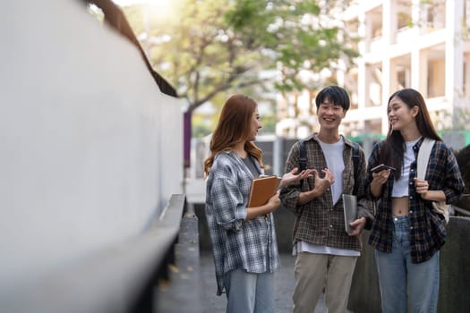 Group of Asian college student reading books and tutoring special class for exam on grass field at outdoors. Happiness and Education learning concept. Back to school concept. Teen and people theme...