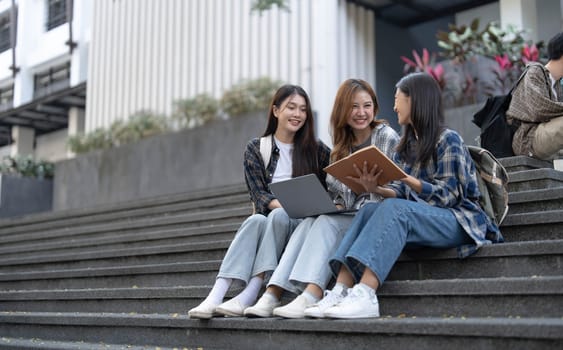 Group of Asian college student reading books and tutoring special class for exam on grass field at outdoors. Happiness and Education learning concept. Back to school concept. Teen and people theme...