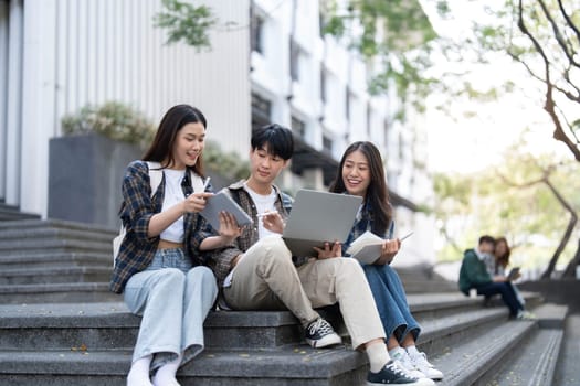 Group of Asian college student reading books and tutoring special class for exam on grass field at outdoors. Happiness and Education learning concept. Back to school concept. Teen and people theme...